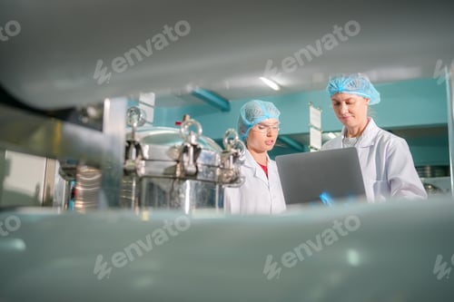 Preview: Female worker inspecting water bottle on production line in drink water factory