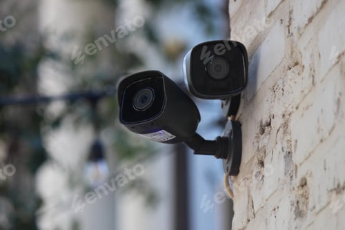 Preview: Closeup shot of outdoor security cameras on a stone wall exterior