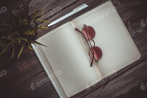 Preview: open notepad with pen and office glasses mobile phone flower in a pot top view interior