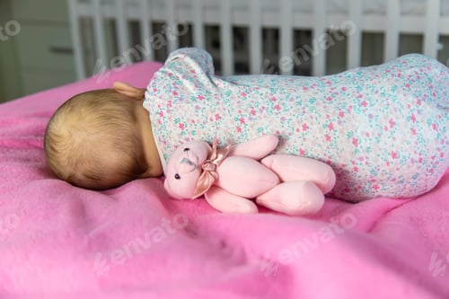 Preview: Baby sleeps with a bear. Selective focus.