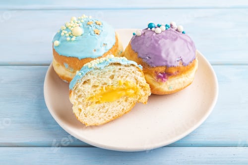 Preview: Purple and blue glazed donut on blue wooden, side view.