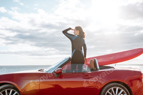 Preview: Woman with surfboard on the car near the ocean