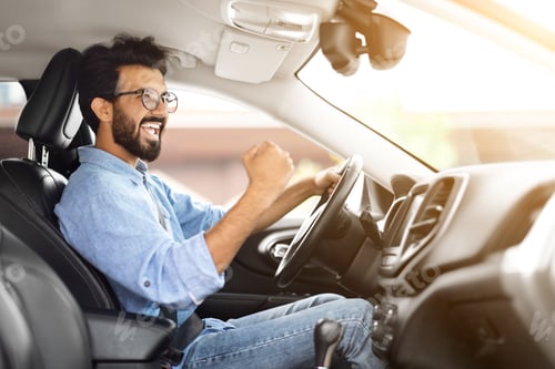 Preview: Happy Young Indian Man Driver Raising Hand up And Exclaiming
