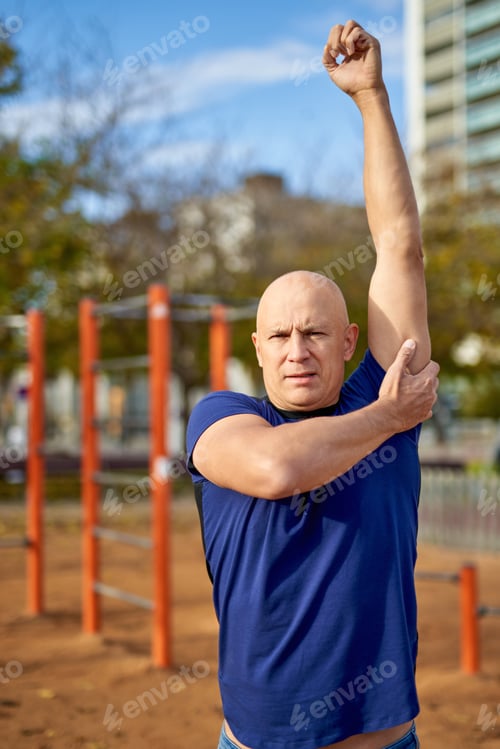 Preview: Athletic Man In T-Shirt Posing Training Doing Stretching Exercising Outdoors