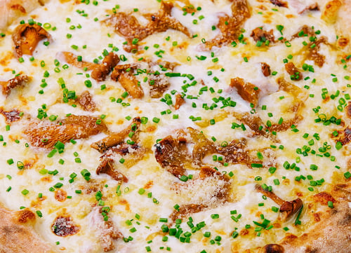 Preview: Freshly baked gourmet pizza on wooden board