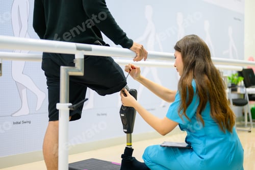 Preview: Physiotherapist adjusting prosthetic leg of patient in hospital
