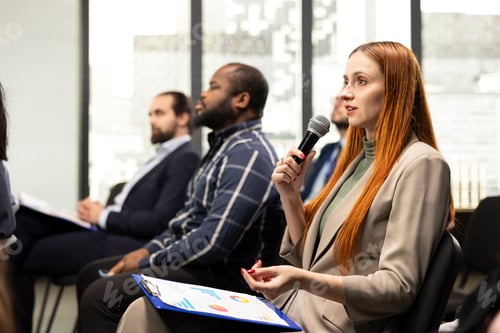 Preview: Young female adult in audience engaging in debate via microphone