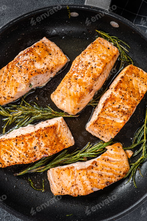 Preview: Grilled Salmon Fillet Steak in a pan. Black background. Top view