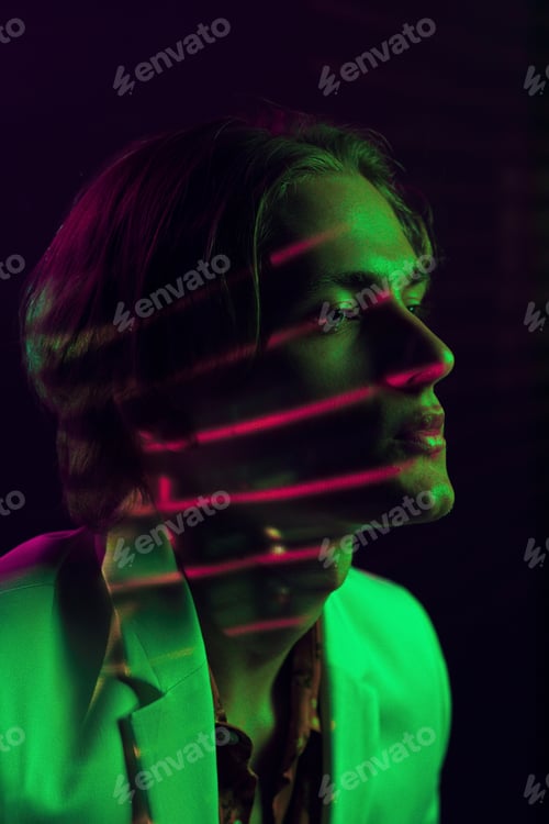 Vista previa: Androgynous man with closed eyes under bright light