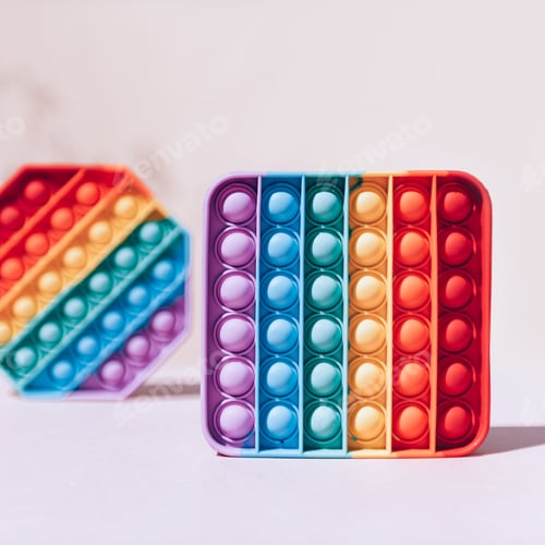 Preview: Bright Rainbow Colored Sensory Toys on White Backdrop