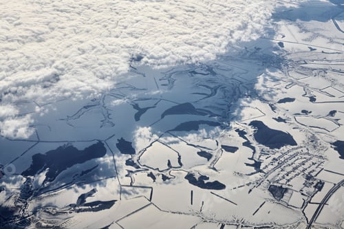 Preview: Aerial cloudscape view over clouds top to snow covered rivers, roads, cities and fields, winter air