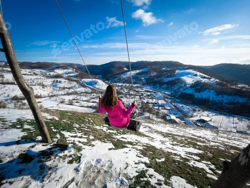 Preview: Woman in a rope swing on top of the mountains with a beautiful panoramic view
