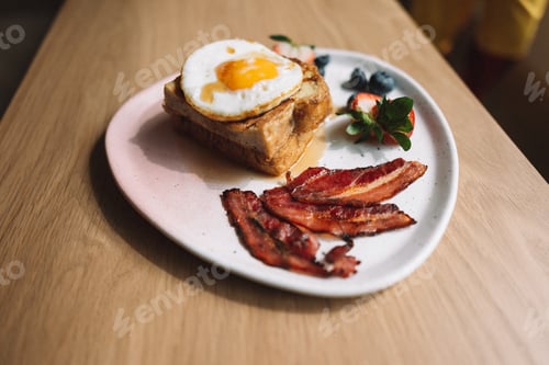 Preview: French toast with egg bacon strawberry and blueberry on wooden table