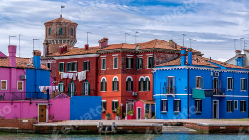 Preview: colorful buildings line the edge of the water near a dock