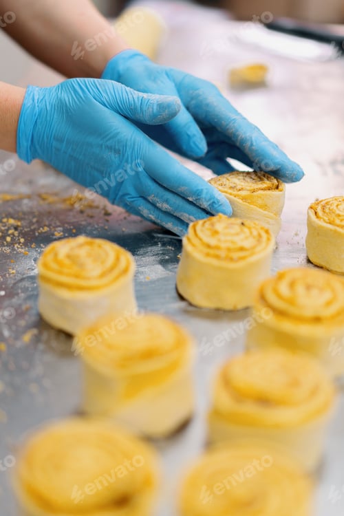 Preview: The kitchen in the bakery the process of making cinnabons, woman baker uses chocolate in granules