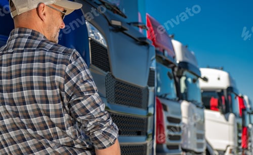 Preview: Professional Driver Inspecting Trucks in a Dealership During Clear Weather