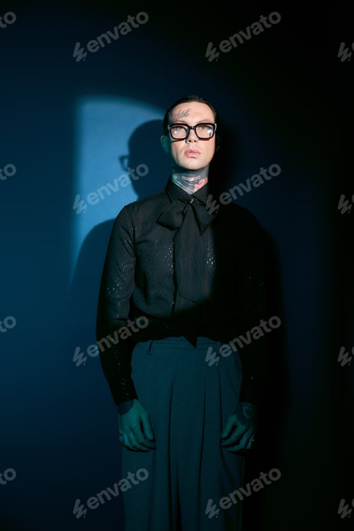 Preview: Stylish young man exuding confidence in a chic outfit against a striking backdrop