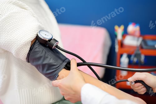 Preview: Female doctor cardiologist measures pressure with patient at medical office of clinic