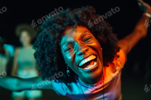 Preview: Young woman dancing with open arms and laughing at night