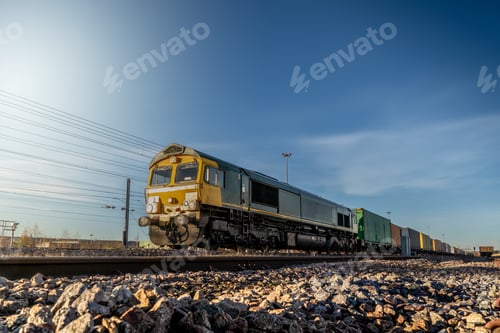 Preview: A UK freight train with locomotive and wagons transporting shipping container boxes