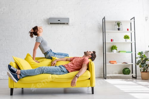 Preview: Couple Relaxing on Yellow Couch in Living Room