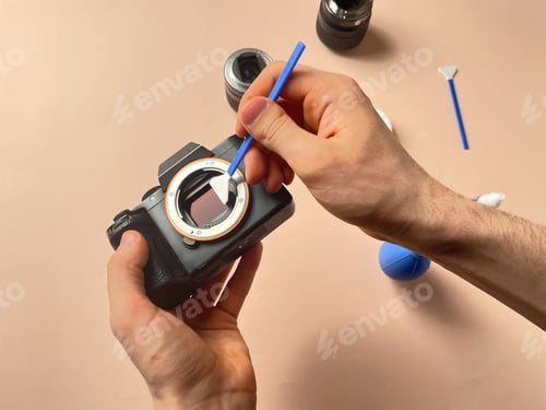 Preview: a person cleaning the photo camera and lens equipment from dirt and dust