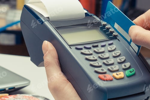 Preview: Hand of woman using payment terminal with credit card. Cashless paying for shopping in shop