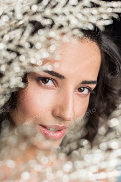 Preview: Close up view of sensual young woman with dark hair looking at camera