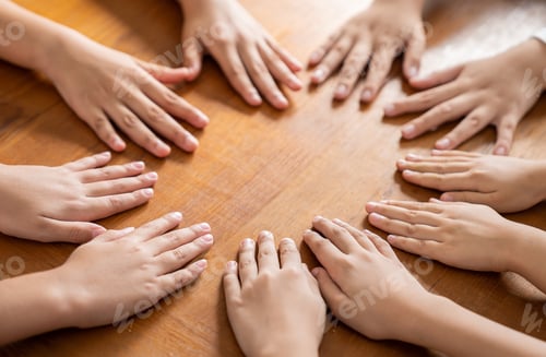 Preview: Multicultural hands man woman children in circle on brown wooden background