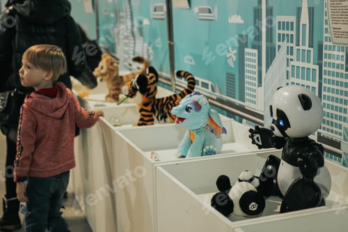 Preview: Futuristic interactive robot toy at exhibition of modern technologies Boy playing Smart technology N