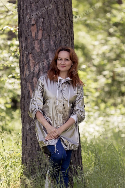 Preview: young woman walking in the spring forest in sunny weather