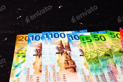 Preview: Closeup of Swiss franc bills on a black background