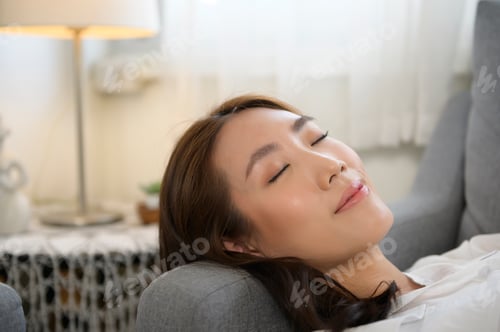 Preview: Young asian woman napping on the sofa in living room