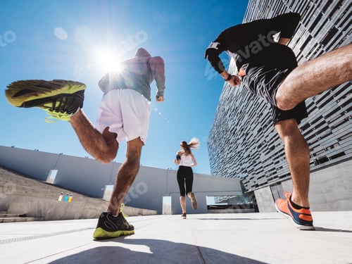Vista previa: tres amigos atletas corriendo en un moderno distrito de edificios