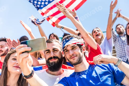 Preview: American fans taking a selfie at stadium during a match
