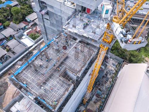 Preview: Aerial view of busy industrial construction site workers working. Development high rise building.