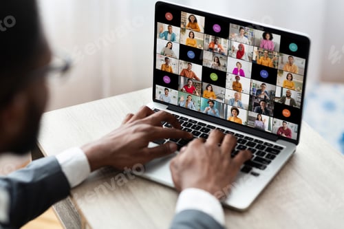 Preview: Man Participating in Large Online Video Conference on a Laptop