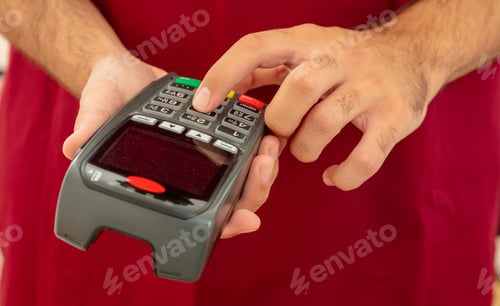 Preview: Man typing on a POS terminal, payment with credit card. Banking, shopping concept.
