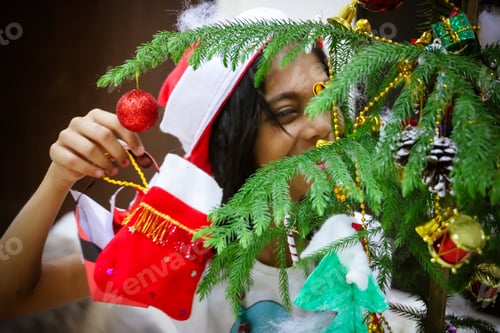 Preview: Little girl happy decorating the Christmas tree