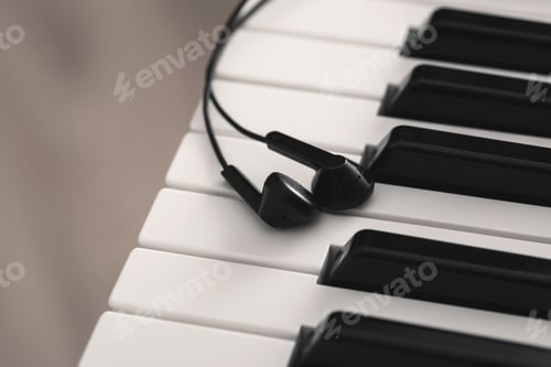Preview: Closeup of earphones over piano or synthesizer keyboard
