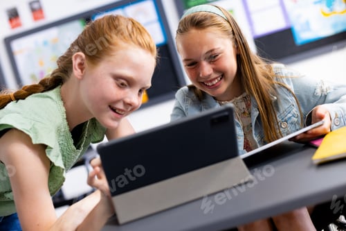 Preview: Happy diverse schoolchildren sitting at desks in school classroom