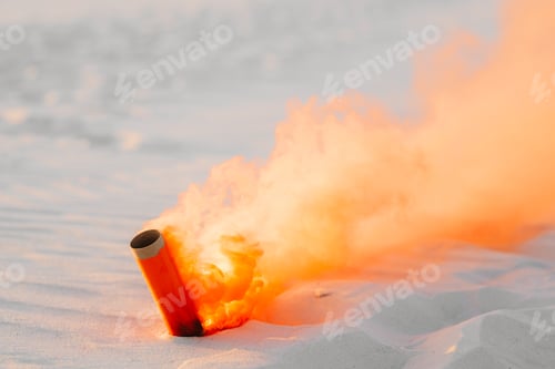 Preview: smoke bomb with orange smoke stuck in the sand