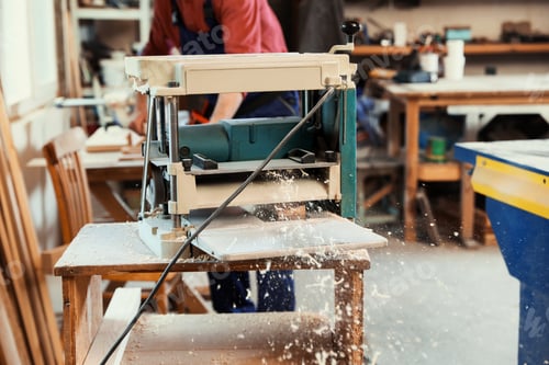 Preview: Working man using thickness planer at carpentry shop, closeup