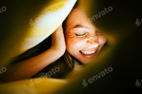 Preview: Portrait of cheerful attractive caucasian woman lying under the blanket at home and having fun