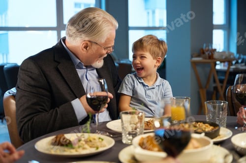 Preview: Grandfather and grandson sitting at a festive table