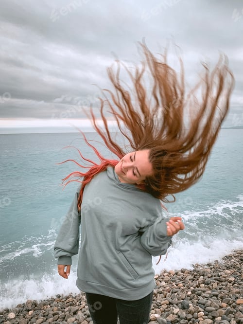 Preview: Woman with flying hair near the sea