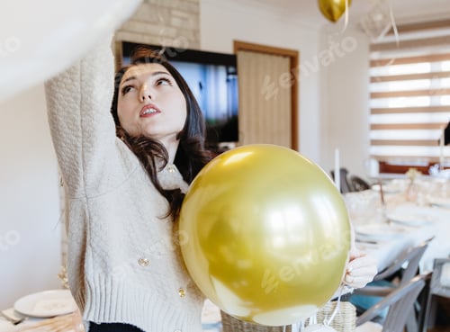 Preview: A beautiful girl holds a golden balloon in her hands.