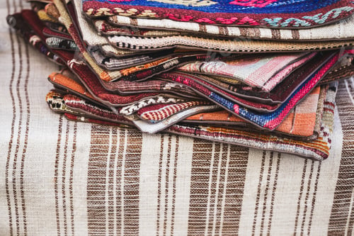 Preview: Pile of beautiful handmade carpets on the market in Istanbul Grand Bazaar. Multicolor background