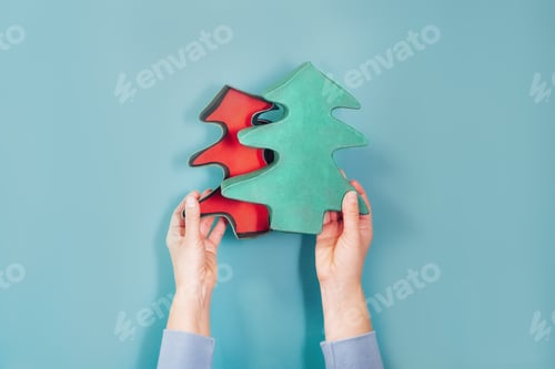 Preview: Top view female hands holding open empty Christmas gift box in the shape of Christmas tree
