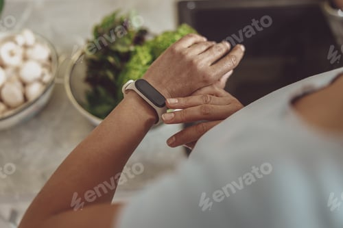 Preview: Closeup of female hand with wrist band. Woman cooking healthy salad